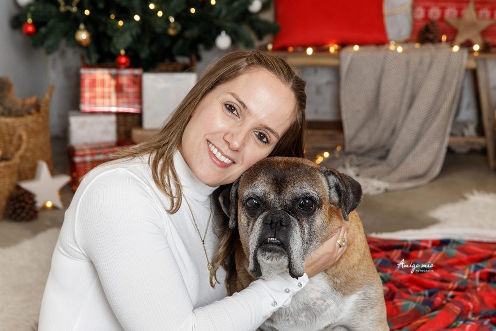 chica abraza su perro con un decorado navideño en una sesión en el wlam 2019