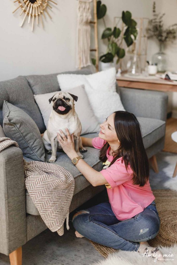 chica acariciando a su carlino en una sesión