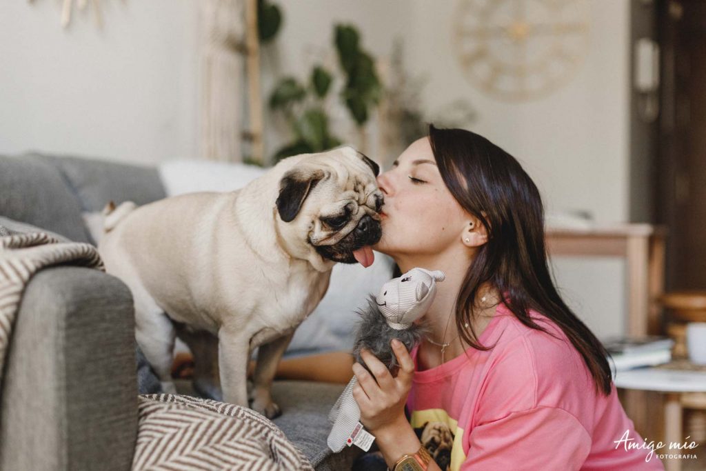 chica Chloe dando un beso a su carlino Alex en una sesión familiar