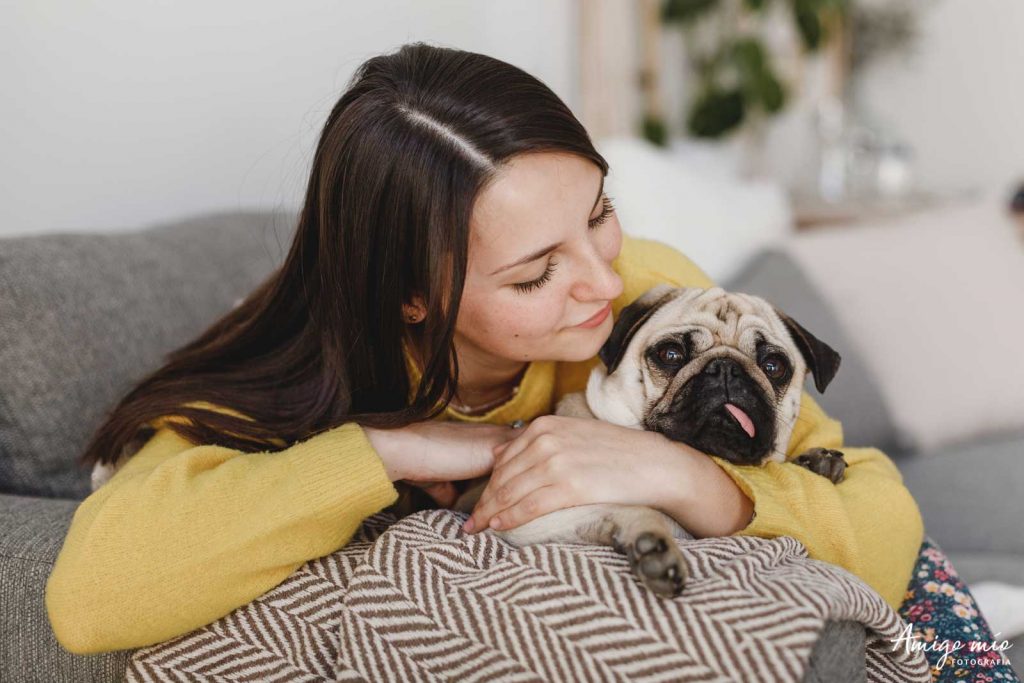 chica Alex mirando a su perro carlino Chloe en una sesión familiar