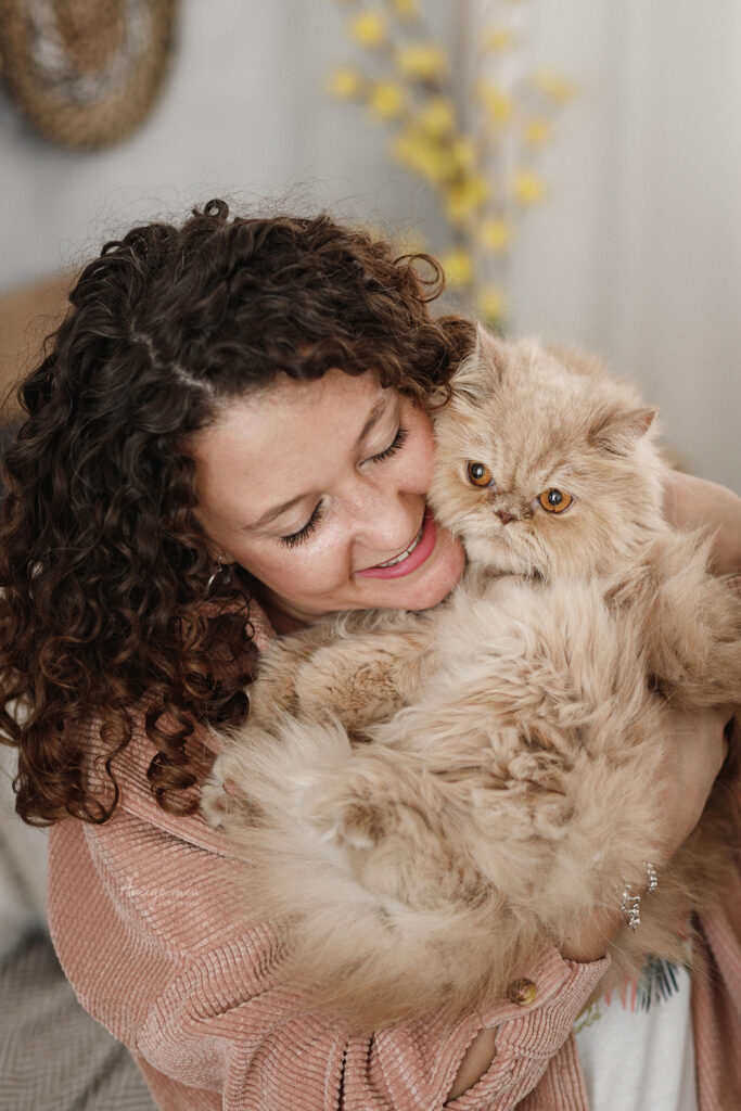 madre gatuna mimando a su gato tumbado en una cama en un reportaje fotográfico de amigo mío fotografía
